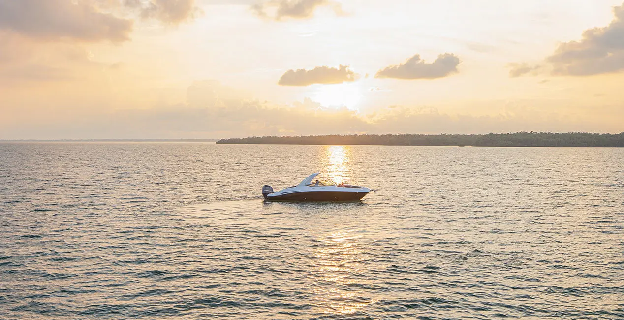 A Hurricane Yacht Certified boat floating on the ocean at sunset.