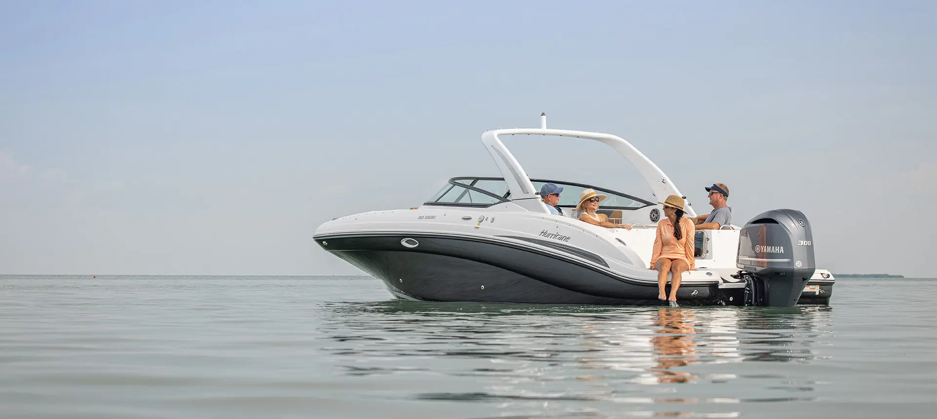 4 people relaxing on a Hurricane Yacht Certified boat while floating the ocean.