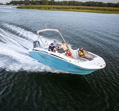 Family speeding across lake on a Hurricane Outboard deck boat.