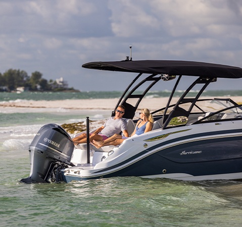 Hurricane Outboard deck boat parked in shallow water.