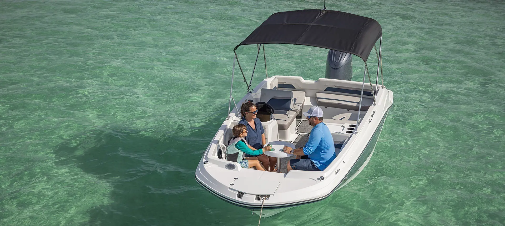 Family hanging in front seating of a Hurricane Outboard deck boat.