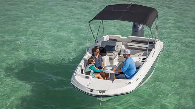 Family hanging in front seating of a Hurricane Outboard deck boat.