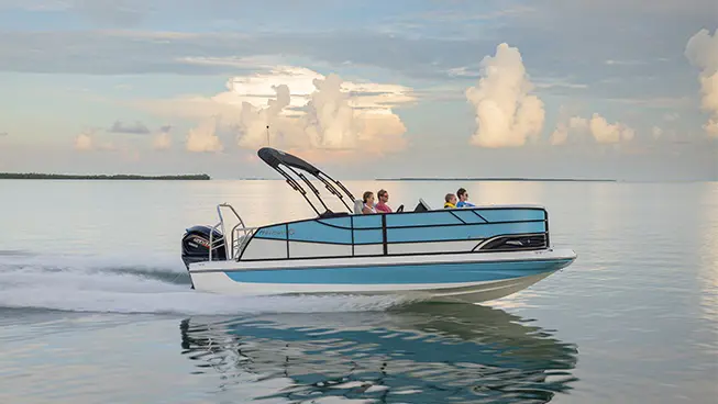 Side view of a Hurricane Outboard deck boat speeding across the water.