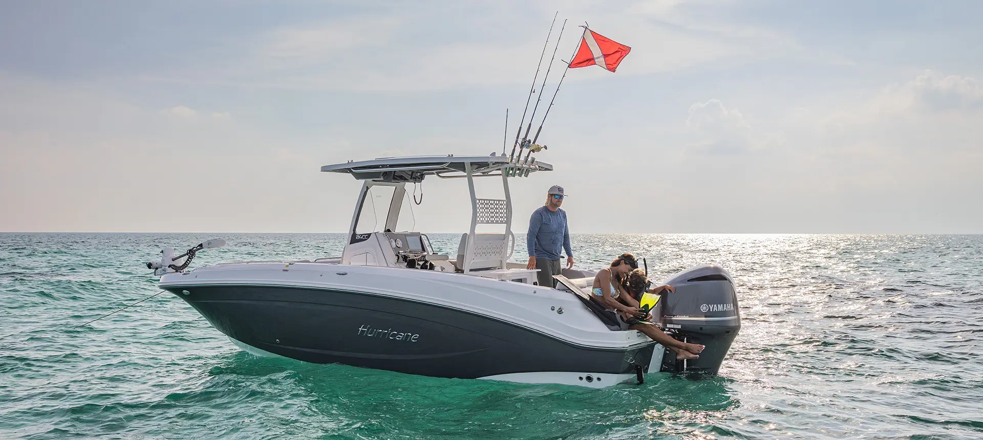 Family preparing to snorkle behind a Hurricane Outboard deck boat.