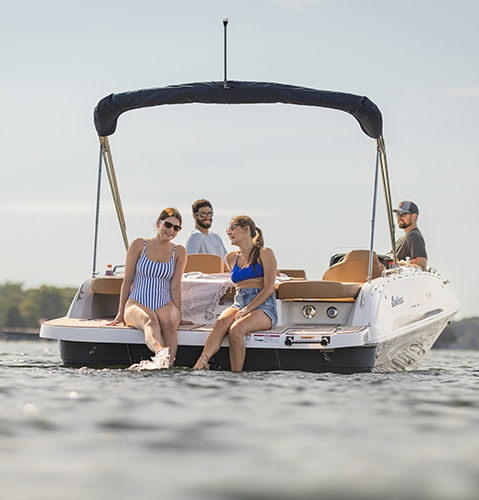 Friends lounging on a parked Hurricane sterndrive io boat.