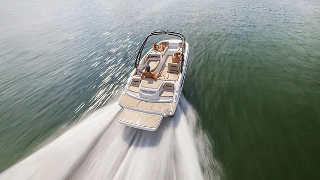 Boy prepares to wakeboard behind a Hurricane sterndrive io boat.