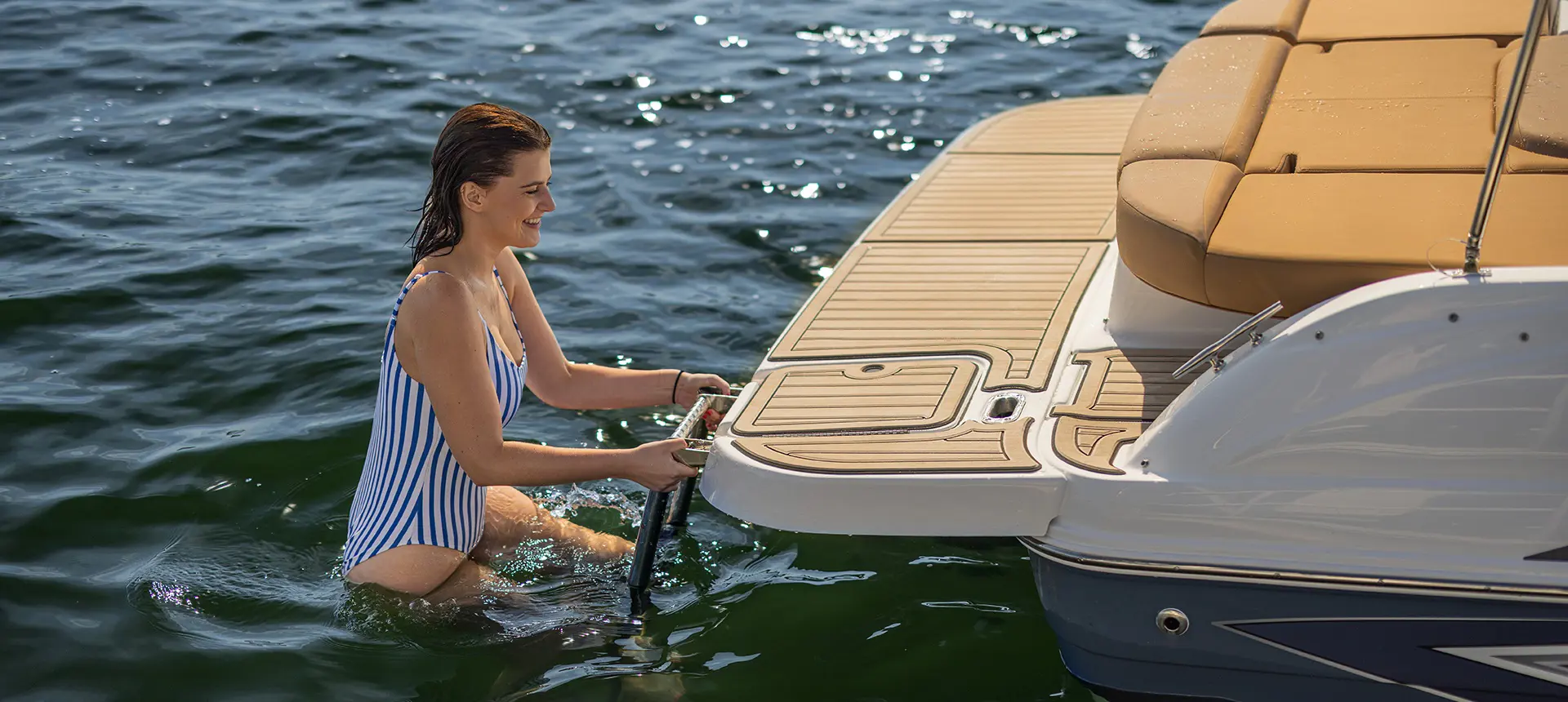 Woman climbing up ladder on a Hurricane sterndrive io boat.