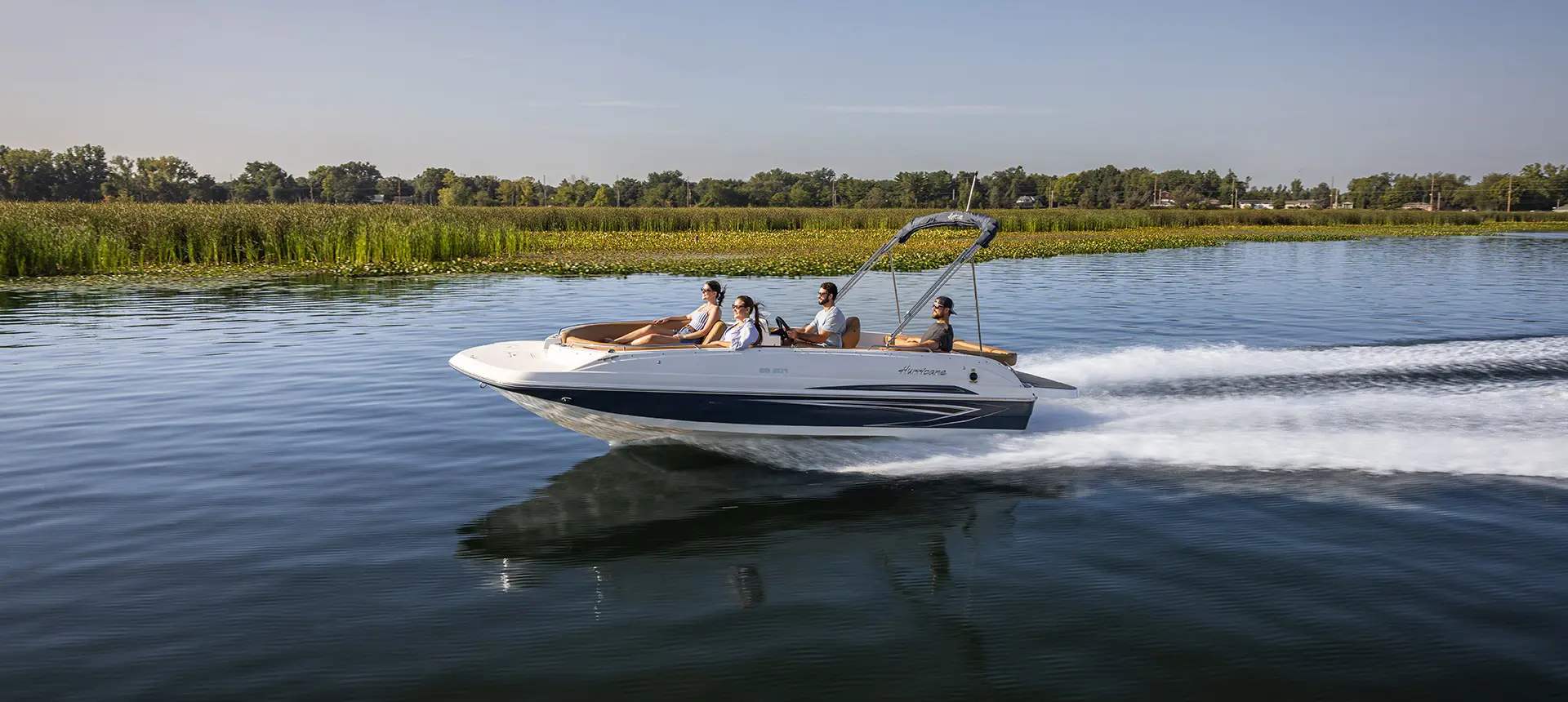 Hurricane sterndrive io boat speeding on lake.