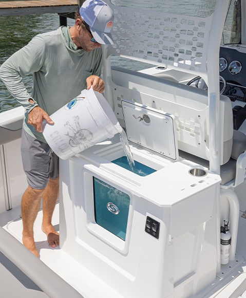Man pouring water into spacious recirculating live well on a Hurricane Center Console boat.