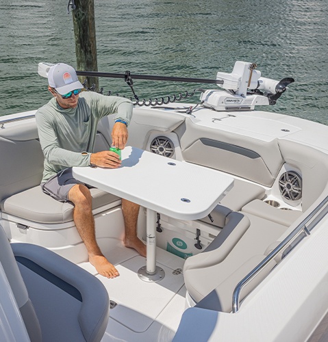 Angler sits in rear seating of a Hurricane Center Console boat.