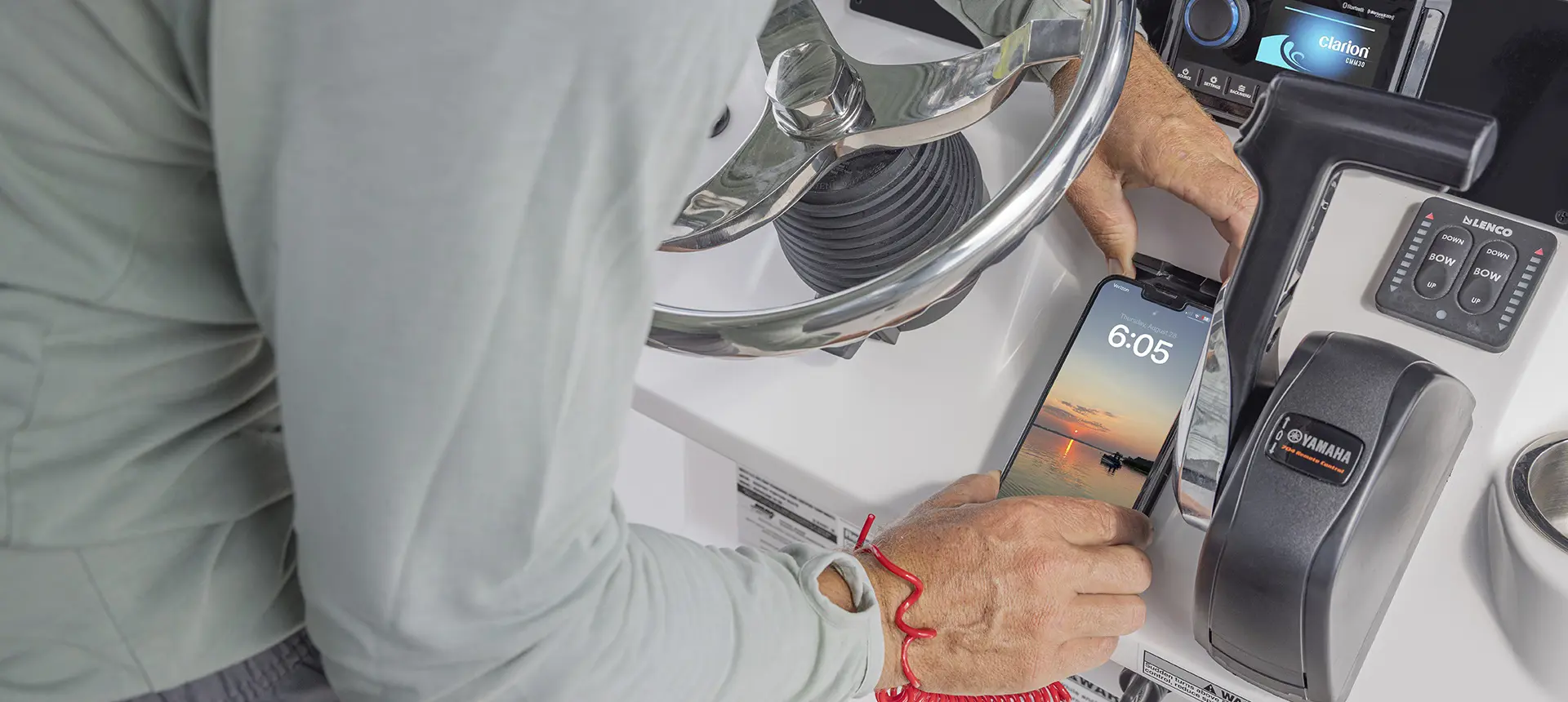 Man putting phone on charging dock station on a Hurricane Center Console boat.