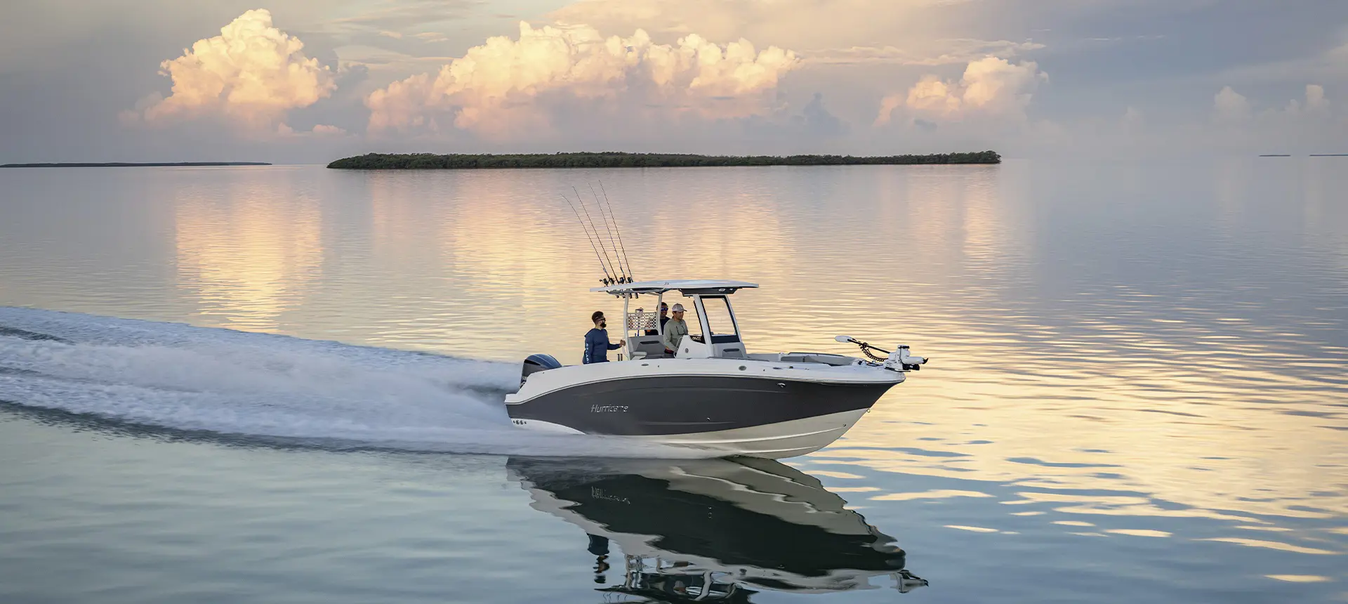 Fishermen cruising across water with mounted fishing poles on a Hurricane Center Console boat.