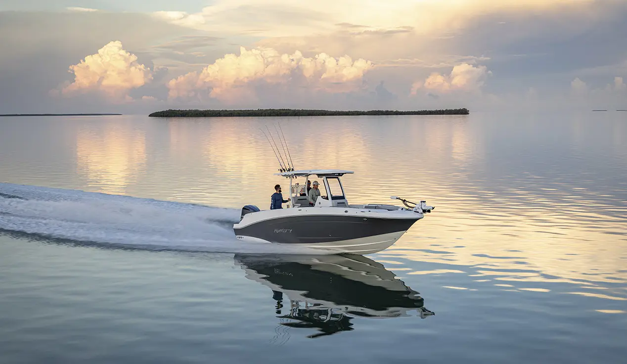 Fishermen cruising across water with mounted fishing poles on a Hurricane Center Console boat.