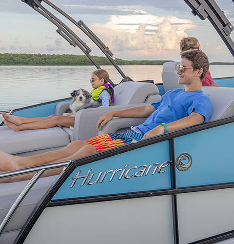Family lounging in rear lounge layout on a Hurricane FunDeck boat.