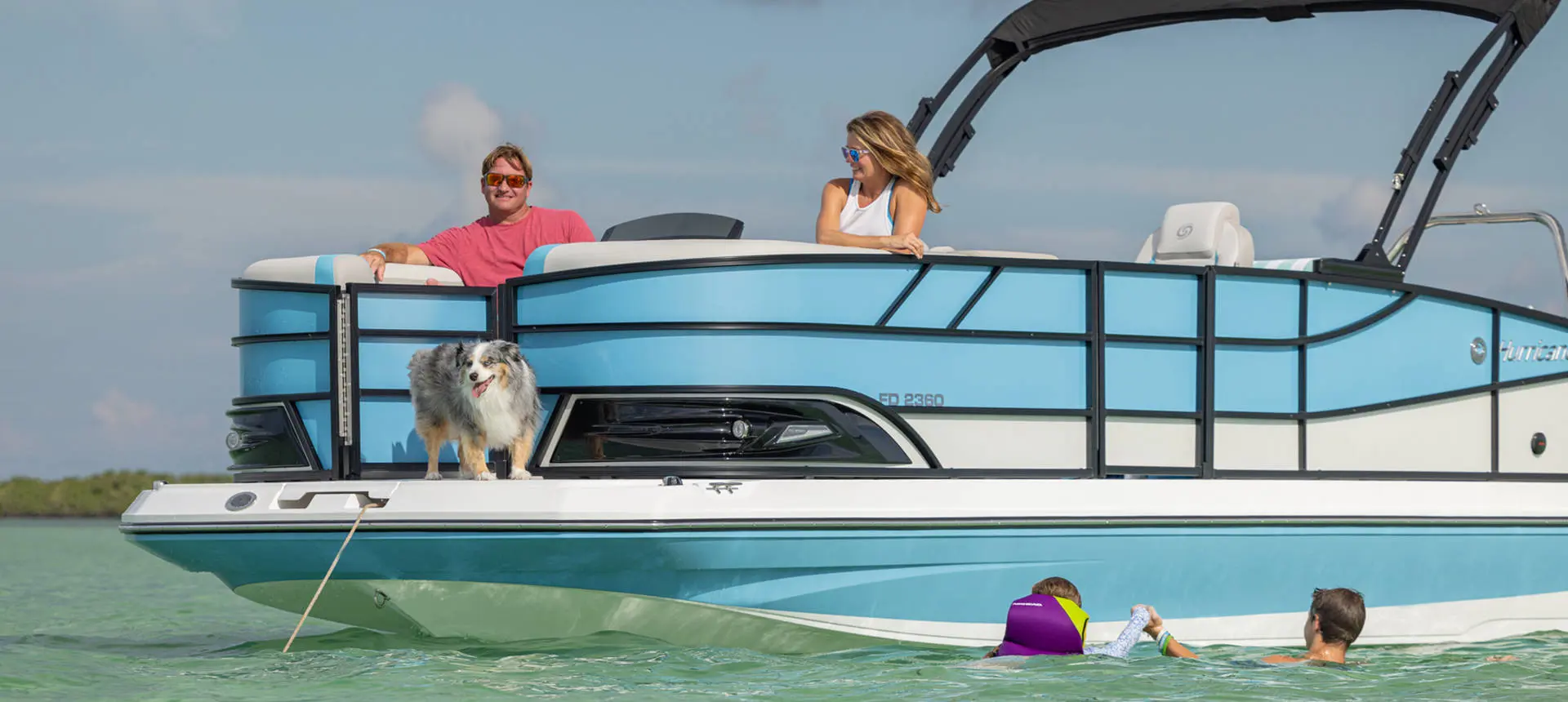 Kids playing in water alongside an anchored Hurricane FunDeck boat.