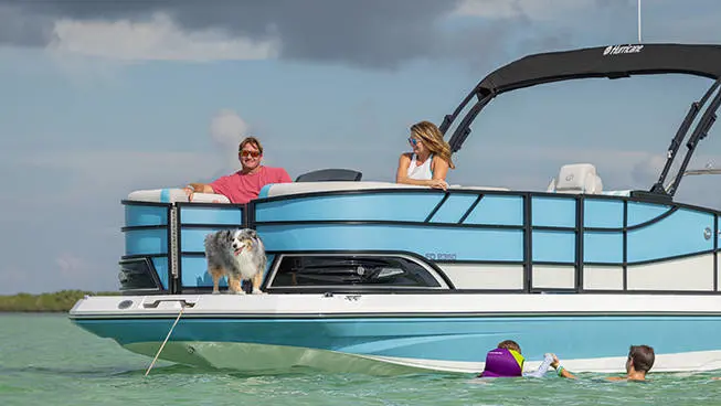 Kids playing in water alongside an anchored Hurricane FunDeck boat.
