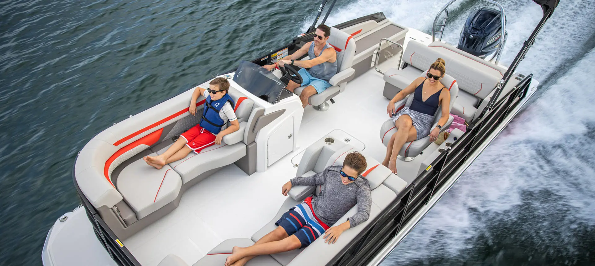 Overhead view of a family seated on a Hurricane FunDeck boat speeding across the water.