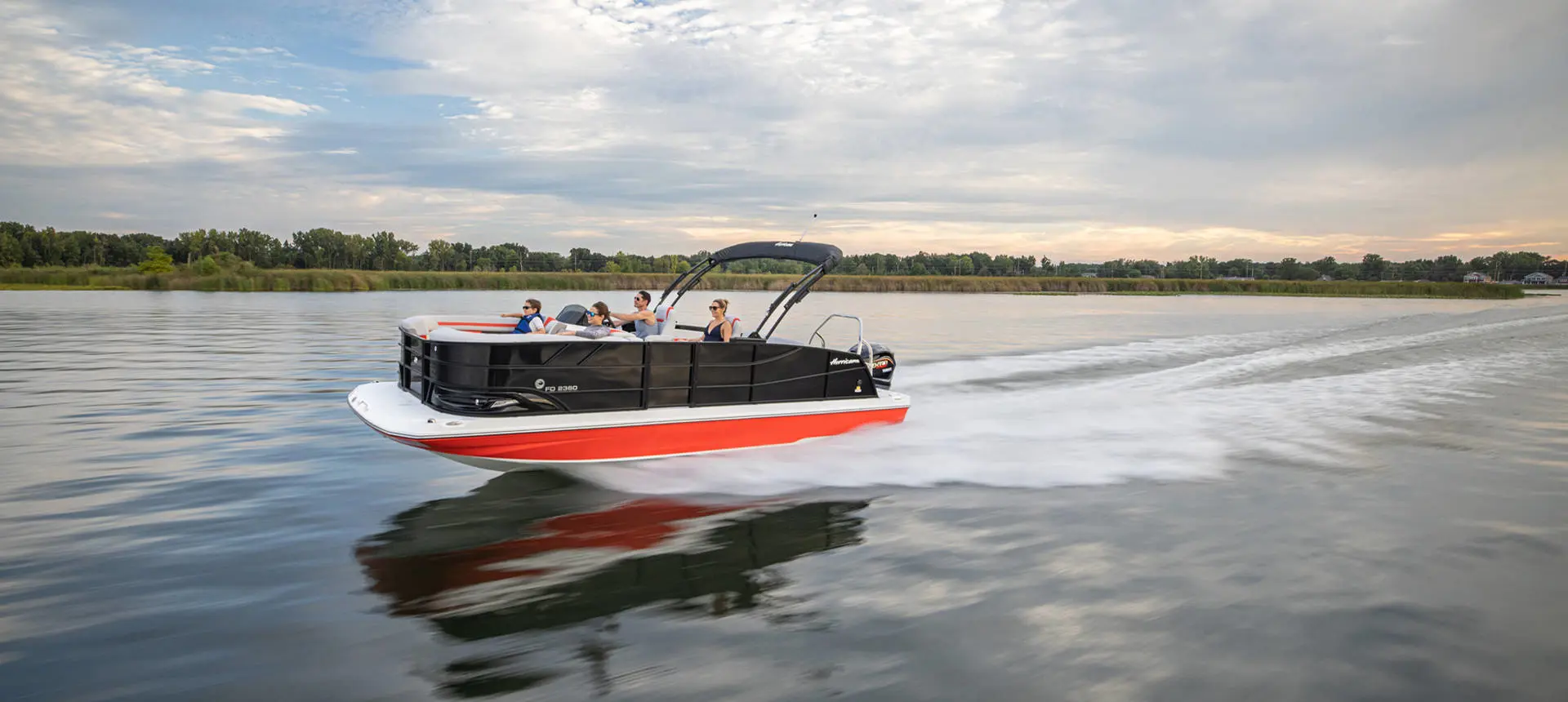 Black and red Hurricane FunDeck boat speeding across the water.
