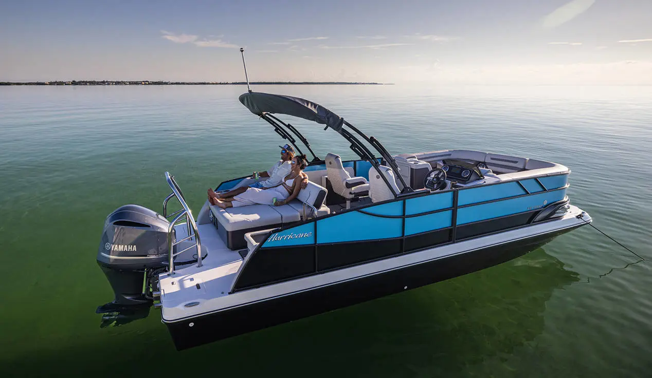 Man and woman relaxing on rear seating of a parked Hurricane FunDeck boat.