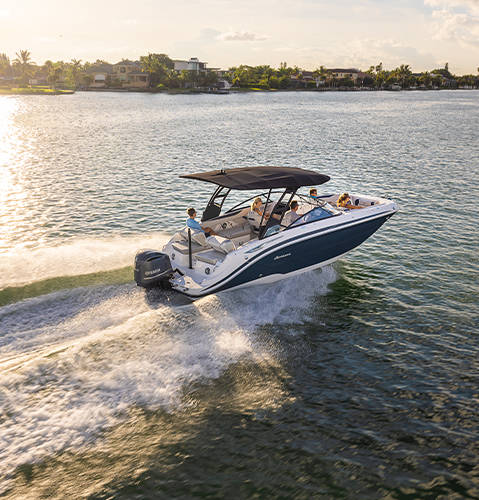Side view of speeding Hurricane SunDeck 2600 Outboard boat on the water.