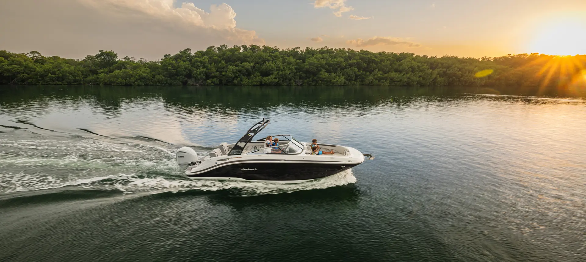 Side overhead view of a Hurricane SunDeck 2600 Outboard boat cruising at sunset.