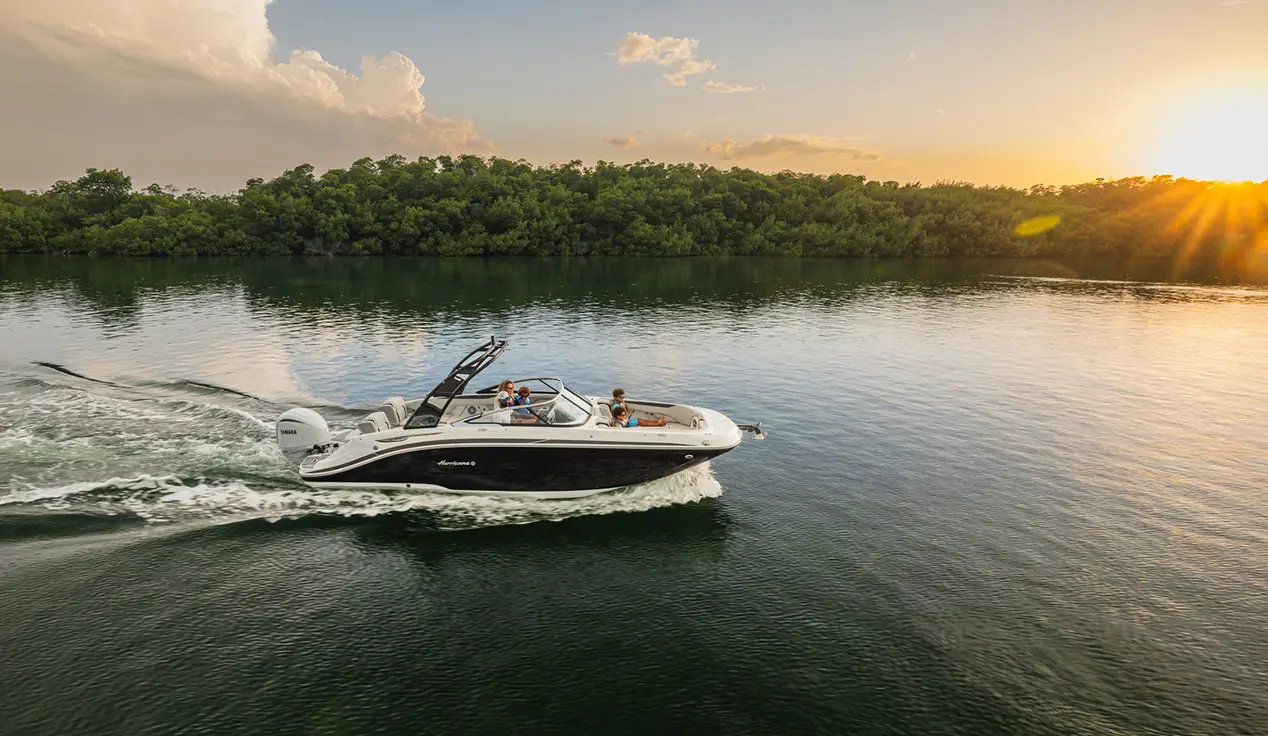 Side overhead view of a Hurricane SunDeck 2600 Outboard boat cruising at sunset.