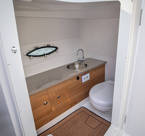 Private enclosed head unit and sink on a Hurricane SunDeck 2690 Outboard boat. 
