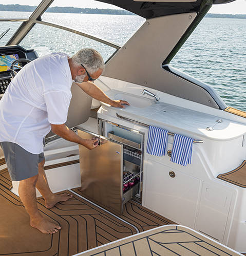 Galley equipped with a fridge, sink, storage, and dedicated prep space on a Hurricane 3200 Outboard boat.