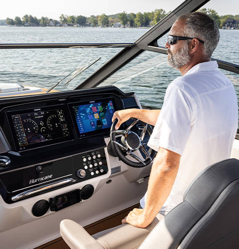 Elevated helm experience with dual 12 inch displays, push button key system, and wireless phone charging on a Hurricane 3200 Outboard boat.
