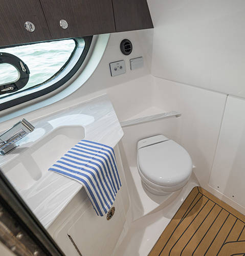 Spacious shower and toilet in under cabin bathroom on a Hurricane 3200 Outboard boat.