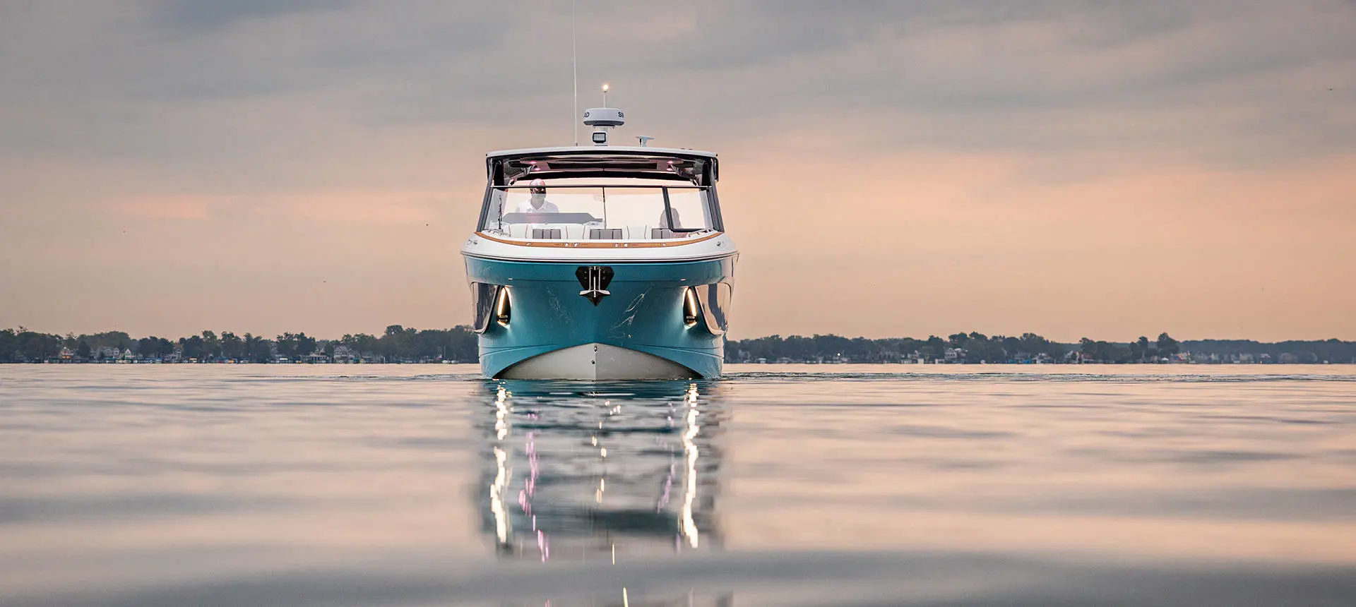 Front view of a Hurricane 3200 Outboard boat parked on the water at sunset.