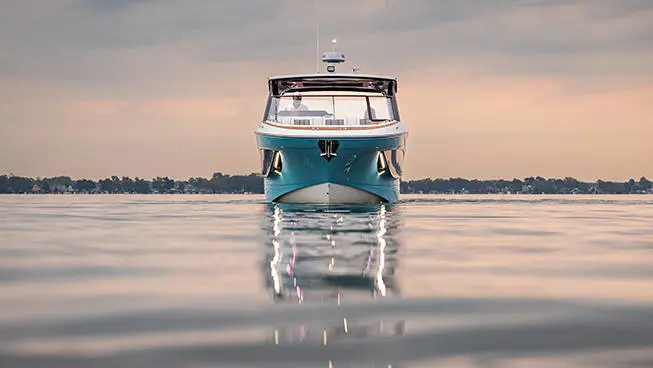 Front view of a Hurricane 3200 Outboard boat parked on the water at sunset.
