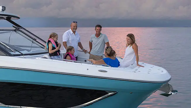 Friends and family chatting at sunset on a Hurricane 3200 Outboard boat.