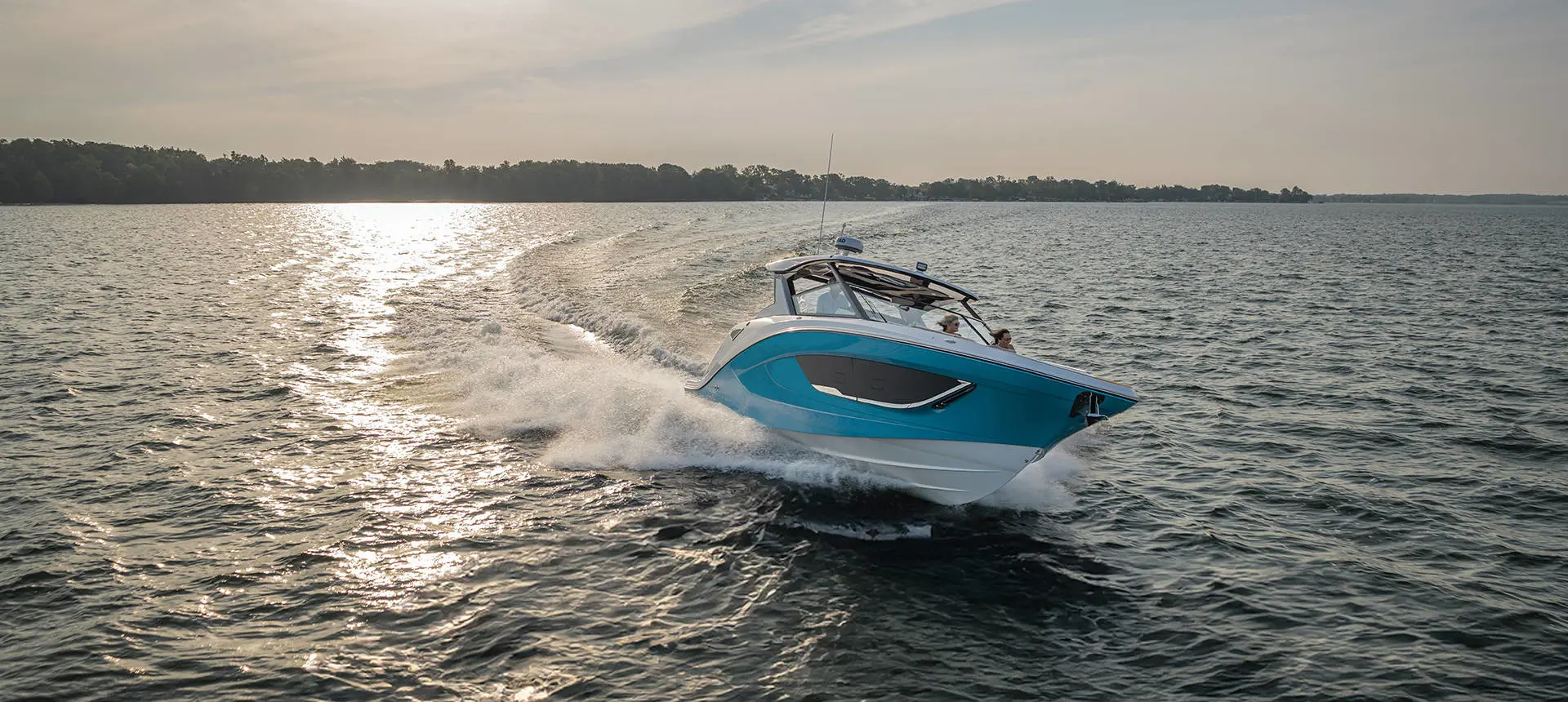 Hurricane 3200 Outboard boat cruising at sunset.
