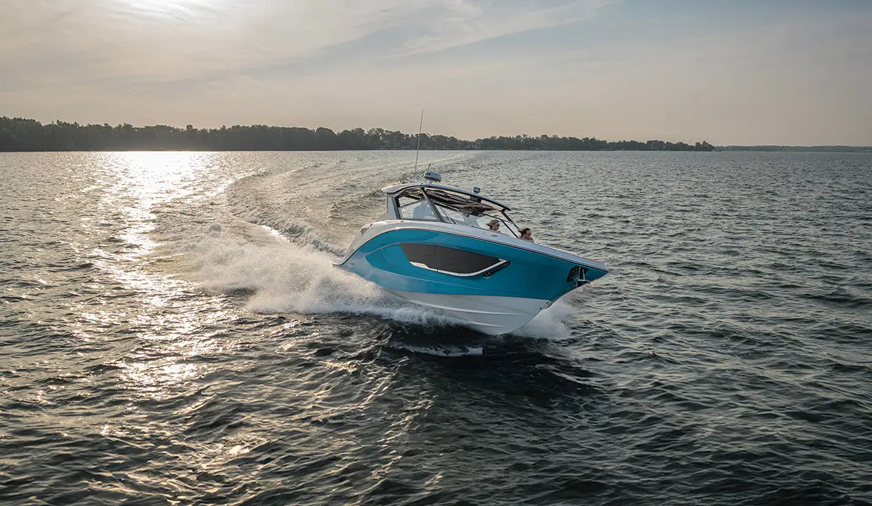 Hurricane 3200 Outboard boat cruising at sunset.