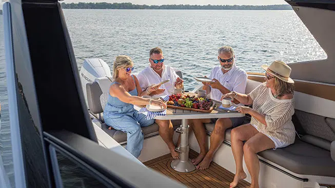 Friends eating snacks on Hurricane 3200 Outboard boat.