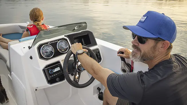 Captain driving a Hurricane SunDeck Sport boat.