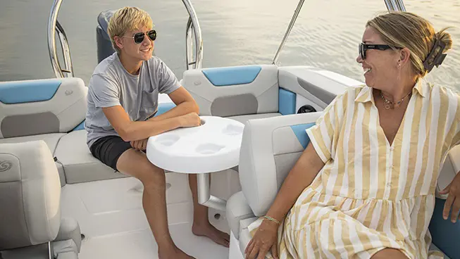 Woman and son laughing in rear seating of a Hurricane SunDeck Sport boat.