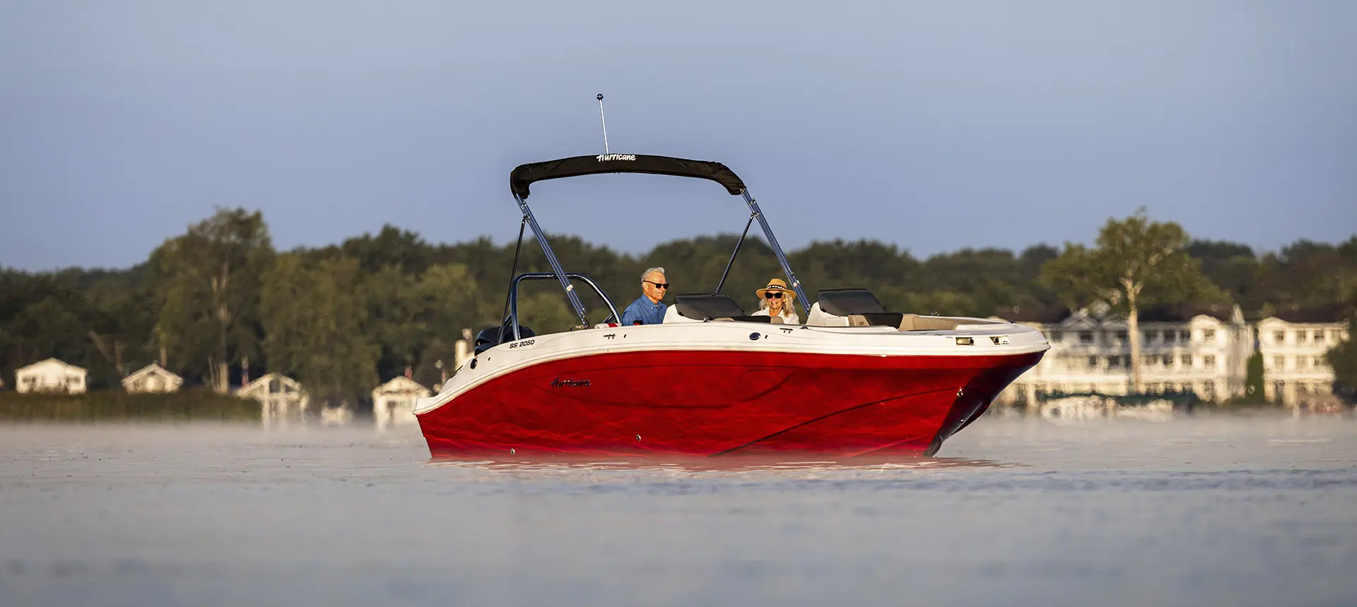 Man and woman parked on the water on a Hurricane SunDeck Sport boat.