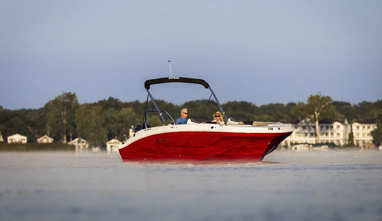 Man and woman parked on the water on a Hurricane SunDeck Sport boat.