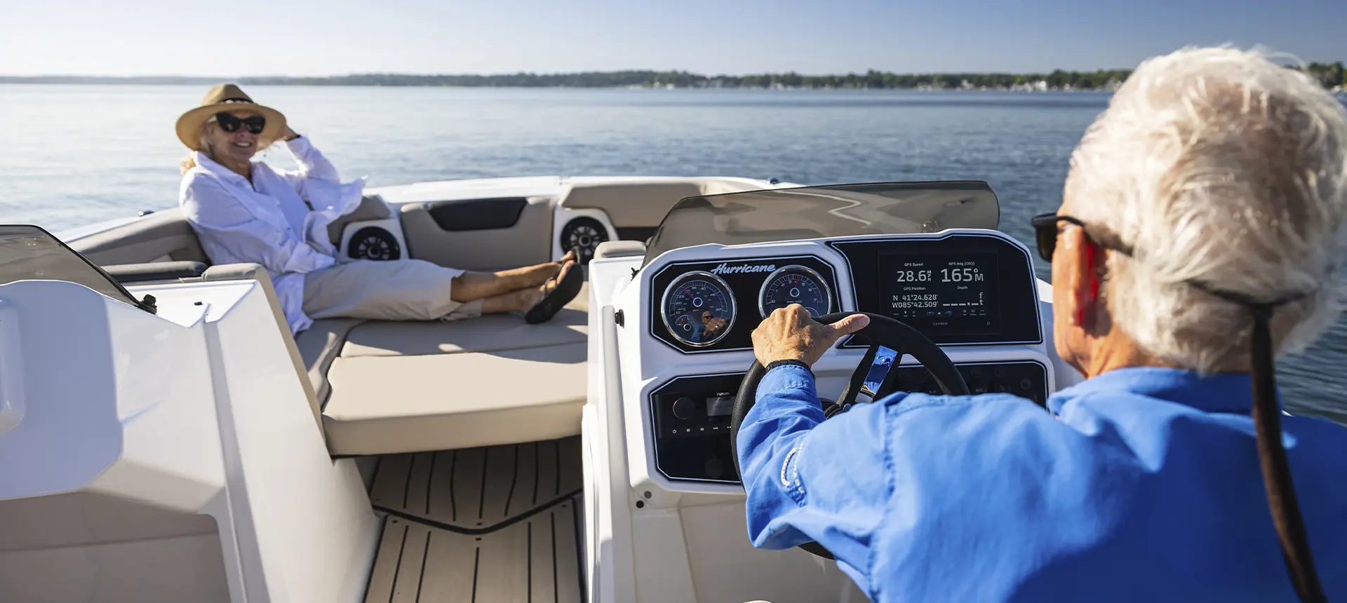 Man driving himself and wife in a Hurricane SunDeck Sport boat.