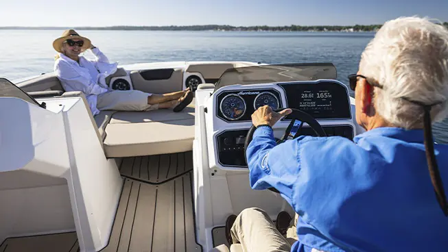 Man driving himself and wife in a Hurricane SunDeck Sport boat.