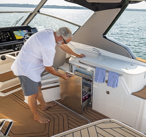 Man opens built-in cooler storage on a Hurricane entertainment boat. 