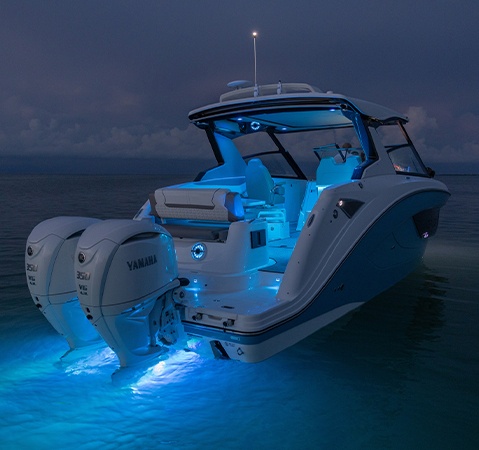 Hurricane entertainment boat parked on water with light blue RGB lighting. 