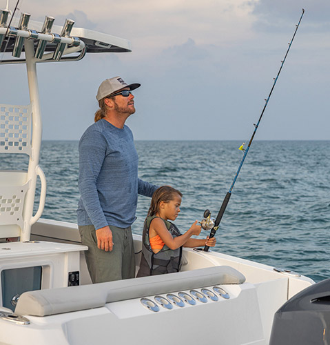 Father and child fishing from a Hurricane fishing boat. 