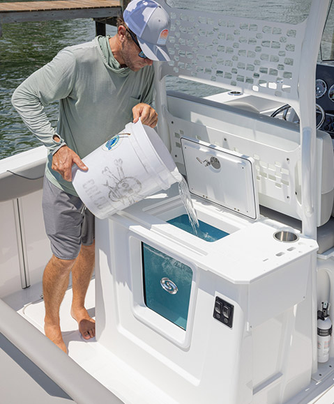 Man dumping water into a livewell on a Hurricane fishing boat. 