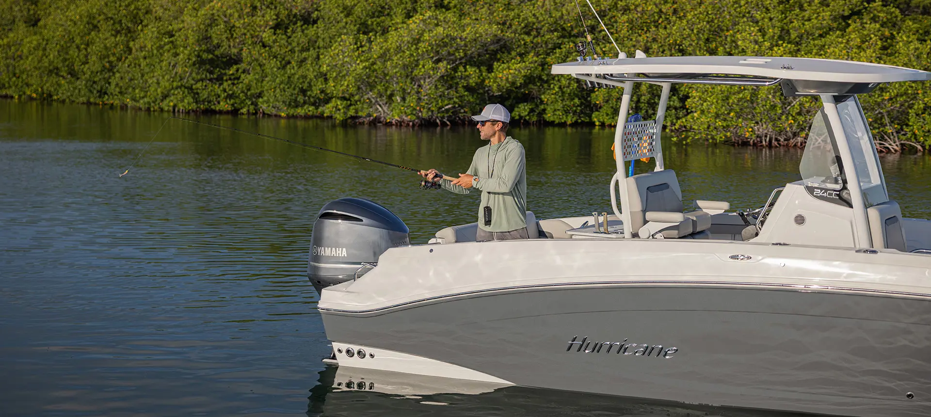 Man casting rod off a Hurricane fishing boat.