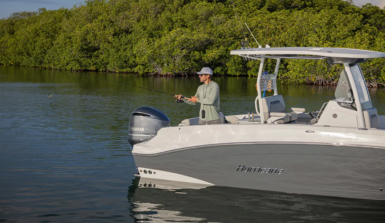 Man casting rod off a Hurricane fishing boat.