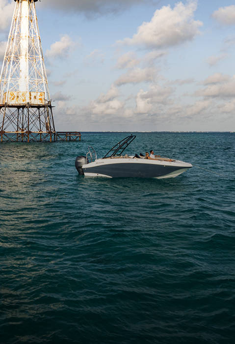 Side view of a parked Hurricane saltwater boat in the ocean. 