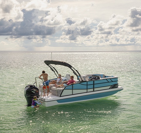 Girl climbing up rear ladder on a parked Hurricane sport boat.